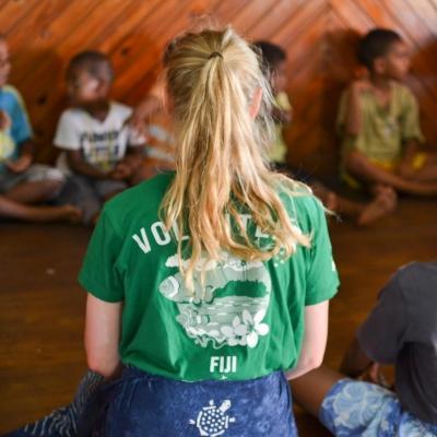 Voluntaria de Projects Abroad realizando una actividad para desarrollar las habilidades de los niños en Fiyi. Voluntaria social en una actividad con los niños de un preescolar en Fiyi.